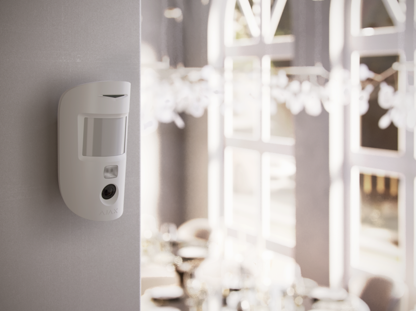 Foto-Bewegungsmelder Bewegungsmelder an einer Wand mit einem hellen, lichtdurchfluteten Raum im Hintergrund.